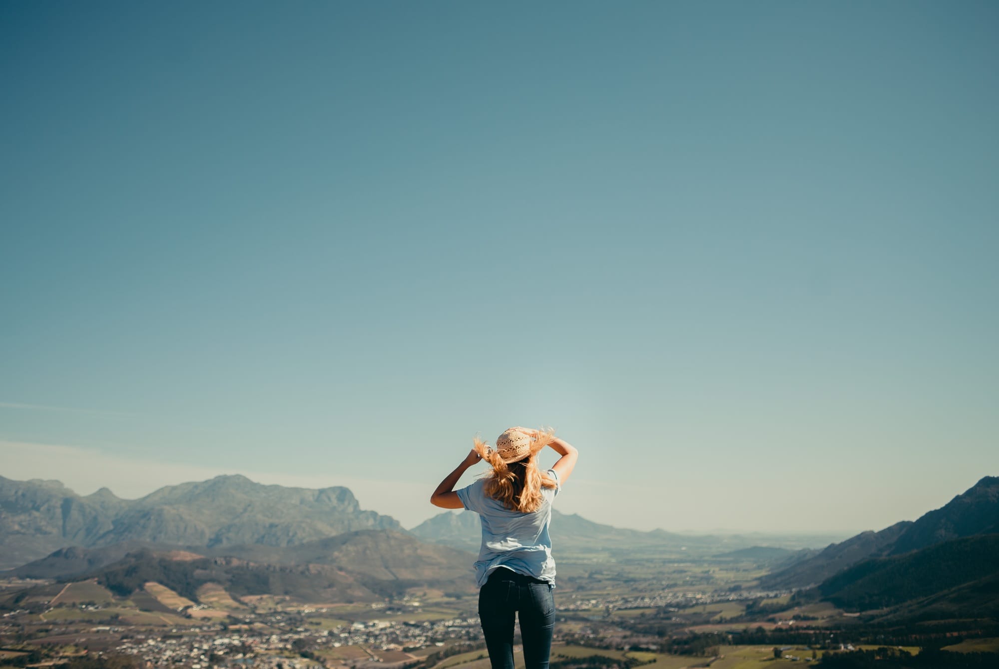 Young woman standing on top of the world